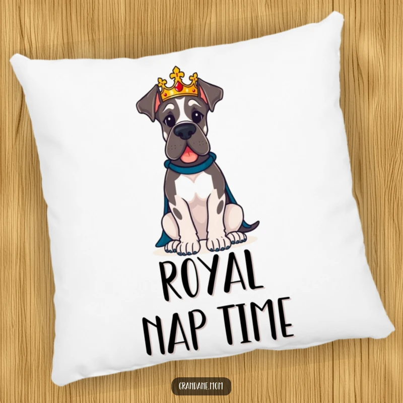 Funny Great Dane dog wearing a crown sits proudly on a plush, humorous pillow.
